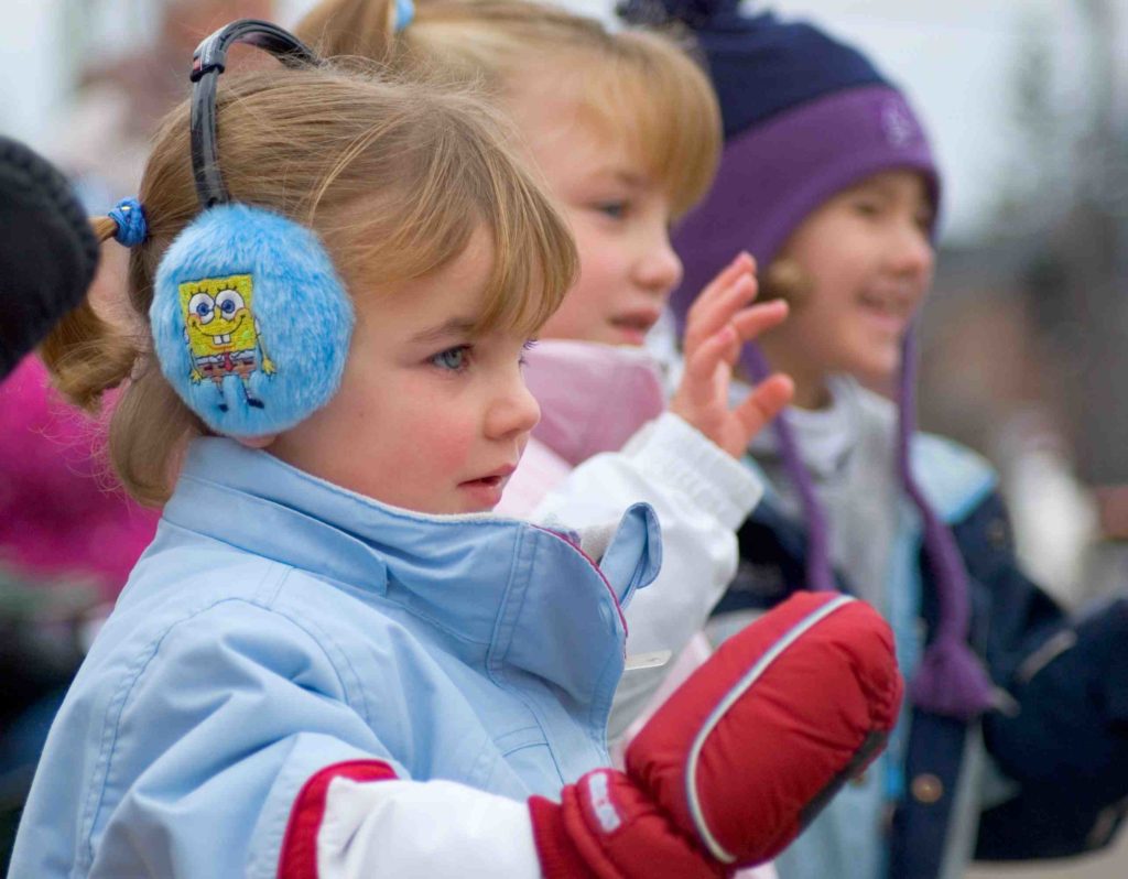 Kids at Santa Claus Parade children waving winter parade