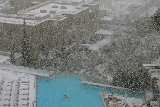 Swimmer in hotel pool while snowing