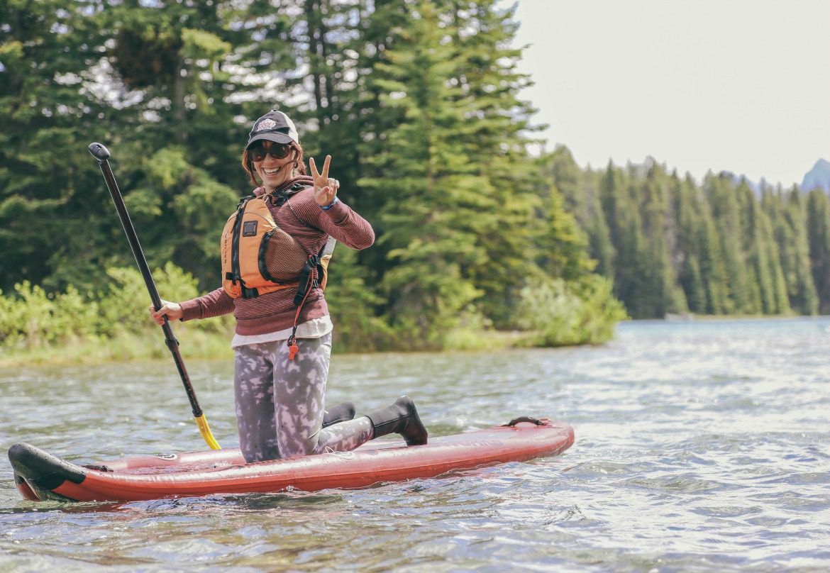 woman paddle boarding in the mountains