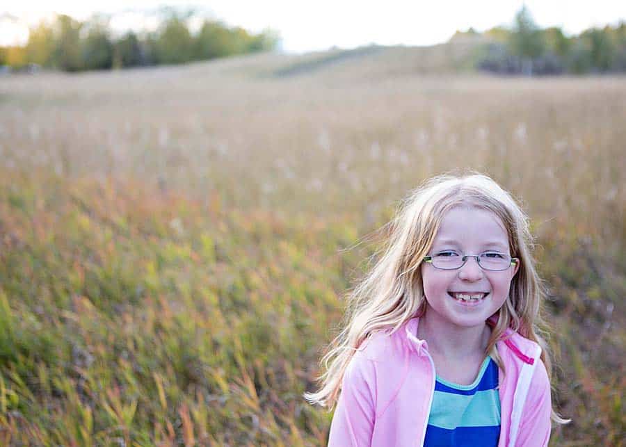 girl in a field wearing glasses