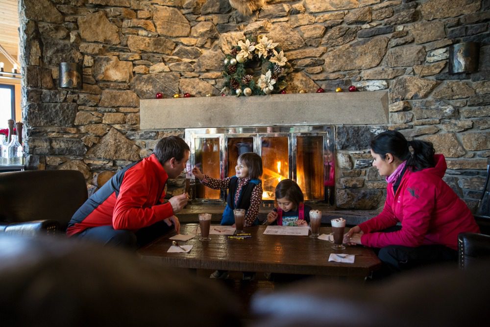 family in front of stone fireplace 