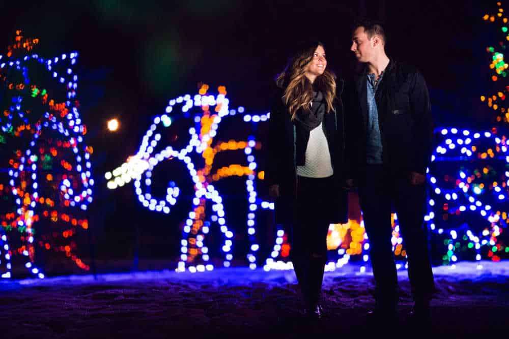 couple walking through holiday light display.